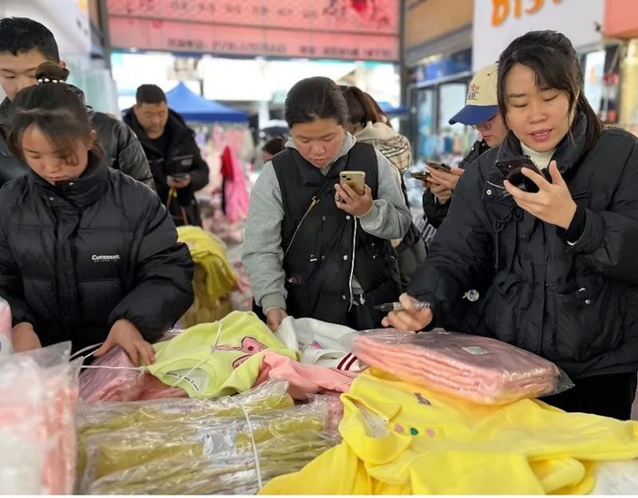 在织里童装市场，很多年轻人通过手机视频为各地经销商推荐童装款式