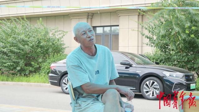 8月9日，杜德路坐在安置区的一个小亭子里唱歌。中青报·中青网 见习记者赵丽梅/摄