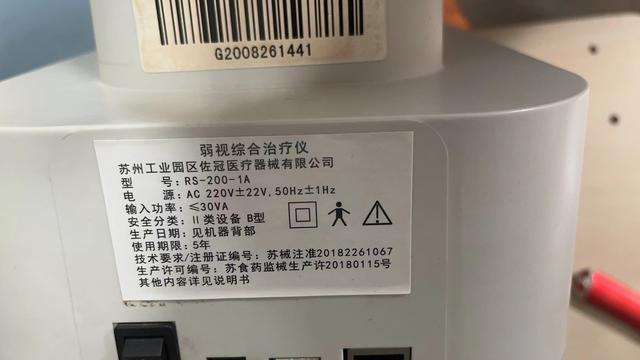 艾尔兴哺光仪底部标签为弱视综合治疗仪，安全分类为二类。受访者供图