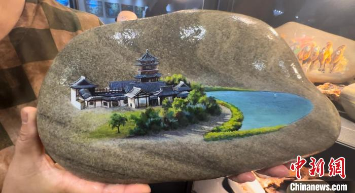 图为马玉兰展示鸣沙山月牙泉石艺画作品。高莹 摄