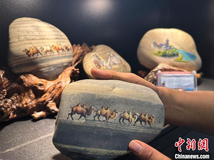 图为绘有丝路驼队的黄河石画作品。高莹 摄