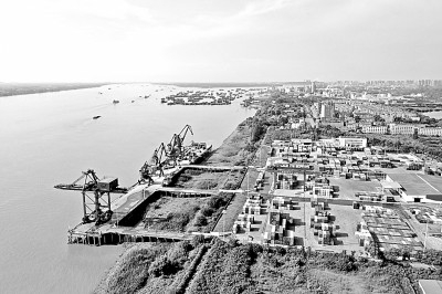     港口机械在安徽铜陵港长江外贸码头装卸物资。光明图片/视觉中国