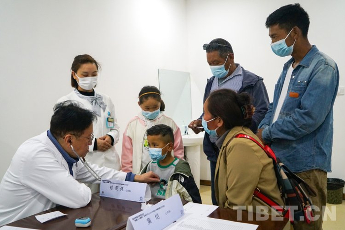 图为徐亚伟教授为藏族小朋友听诊筛查摄影：赵振宇