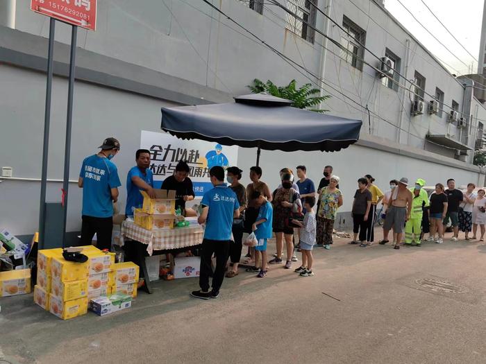 涿州市公益点位向当地居民派发食品供给。