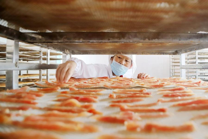 工人在山东省青岛西海岸新区大场镇一家宠物食品企业车间加工出口宠物零食。（图片由CNSPHOTO提供）