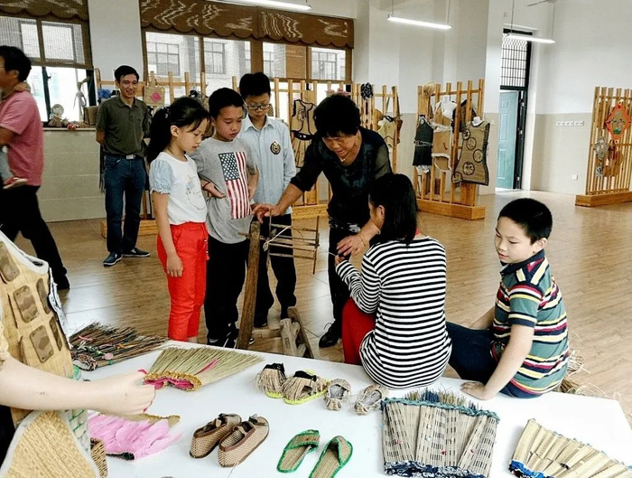 郑仁菊给游客介绍、展示黄古林草席编织技艺。仲一村供图