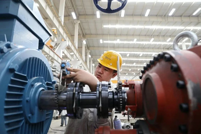 2022年6月15日，辽宁省大连市一家制造企业技术工人在车间内组装设备。图：新华社记者姚剑锋 摄