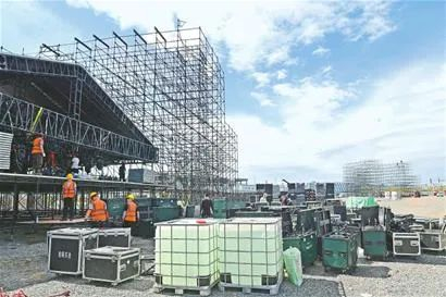 工作人员正在安装调试灯光、音响设备，“唐”舞台已经搭建成型。来源：乌鲁木齐晚报