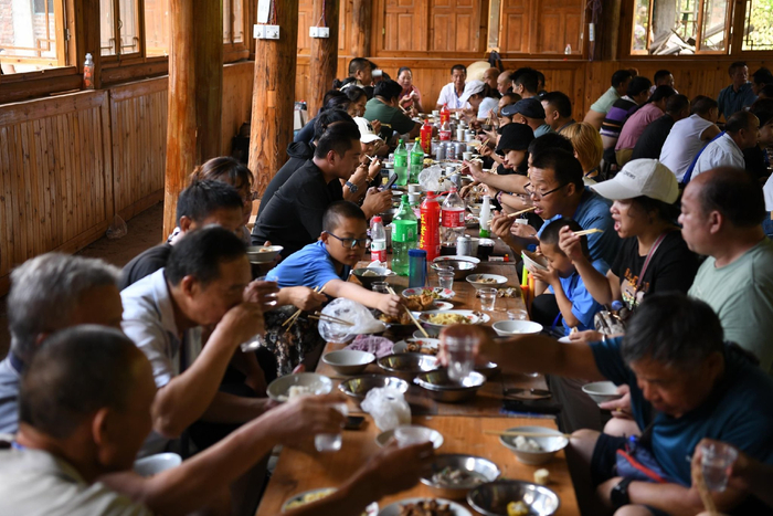 参加“百家宴”的游客在侗寨内品尝侗族美食。广西龙胜县市场监管局供图