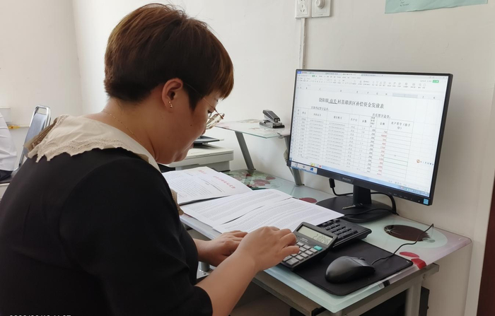 工作人员在核对发放补偿金明细表。