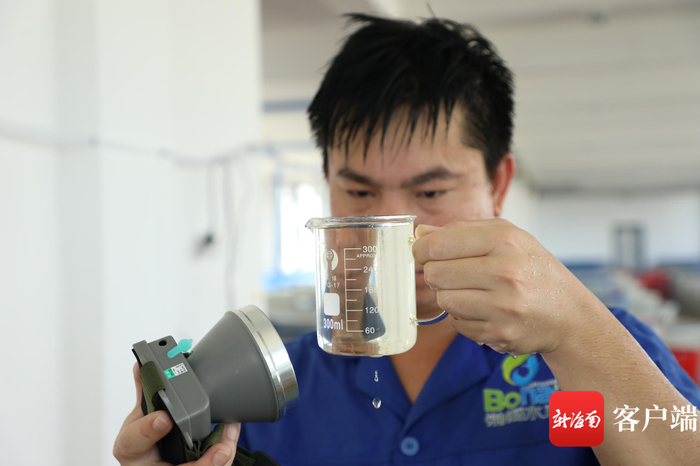 　　工作人员正在查看虾苗的生长情况。记者 郑光平 摄