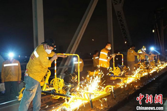 图为南宁工务段职工在湘桂线下行红水河桥上进行钢轨打磨作业。宋彤波 摄