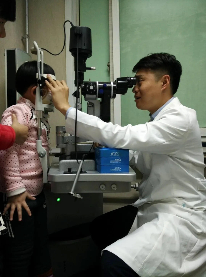 ↑陶勇为儿童做眼部检查 图据央视新闻