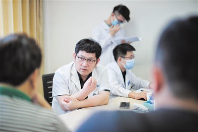 天坛医院神经外科肿瘤一病区主任吴震与患者交流。 摄影/新京报记者 王嘉宁