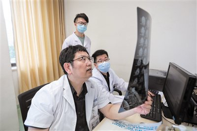 吴震正在看患者影像资料。