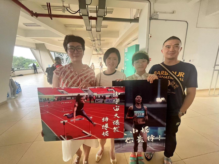 ▲成都大运会女子100米栏比赛，吴母（左一）与亲友到现场为吴艳妮助威。 受访者供图