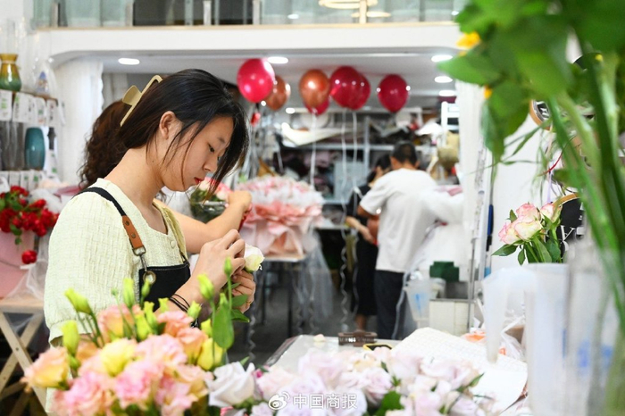 江苏省徐州市睢宁县城区一家花店，员工正在按照订单包装花束。（图片由CNSPHOTO提供）