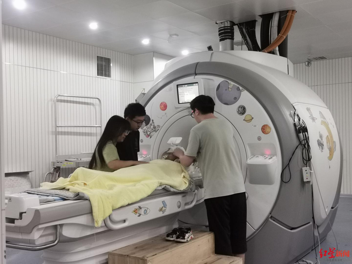 ▲段旭君博士团队为小正进行大脑扫描，检查发育情况
