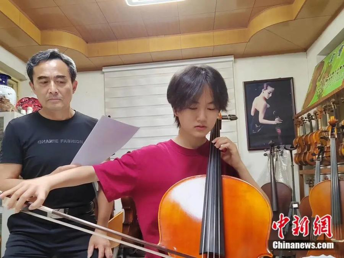 吕官宝指导女儿吕逸菲练琴。受访者供图