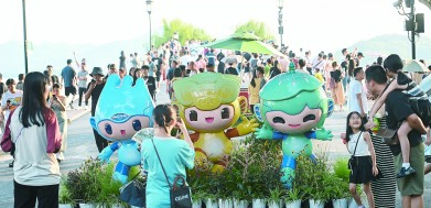 8月21日，游客在位于杭州西湖景区的断桥边与杭州亚运会吉祥物合影。新华社记者&nbsp;黄宗治摄