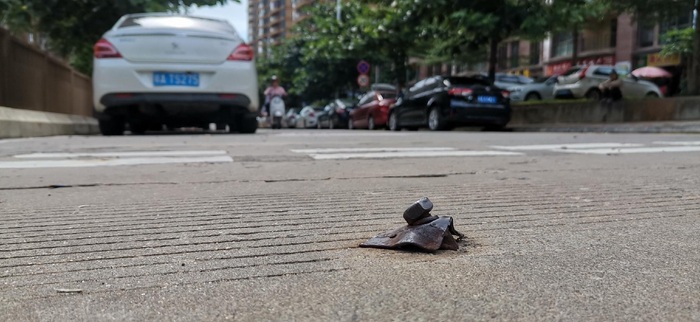 图为长平西街路面上还残留有凸起的金属物。
