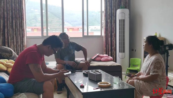 ▲周余杰父母接受红星新闻记者（中）采访