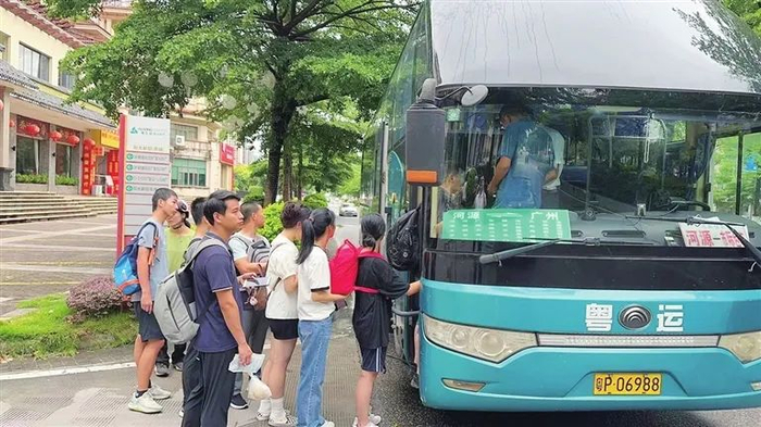 ▲河源粤运滴滴站点巴士上车点，乘客们正在排队上车。