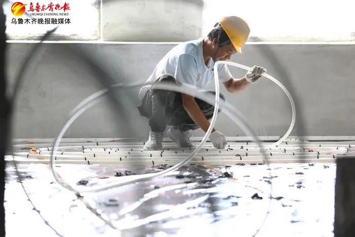 8月23日，在位于高新区（新市区）的通嘉国际港项目现场，施工人员正在进行地暖铺设。乌鲁木齐晚报记者石磊摄