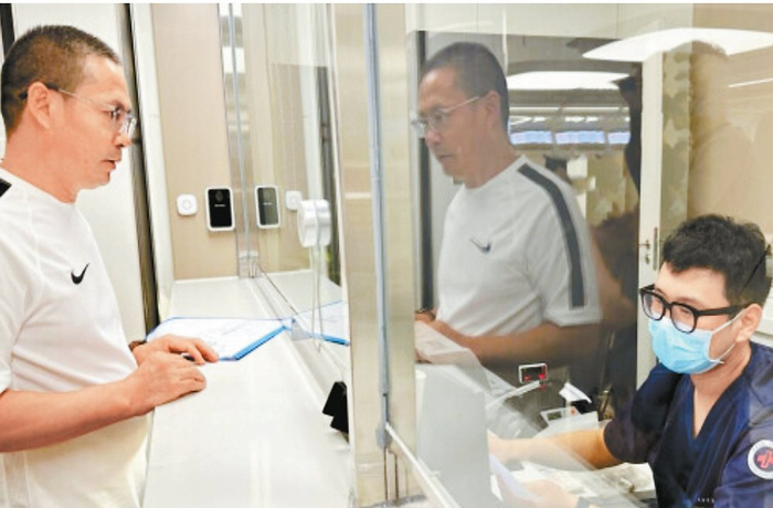 　　荆建华（左）在天津市第一中心医院就医后持医保卡直接办理结算业务。安俐摄