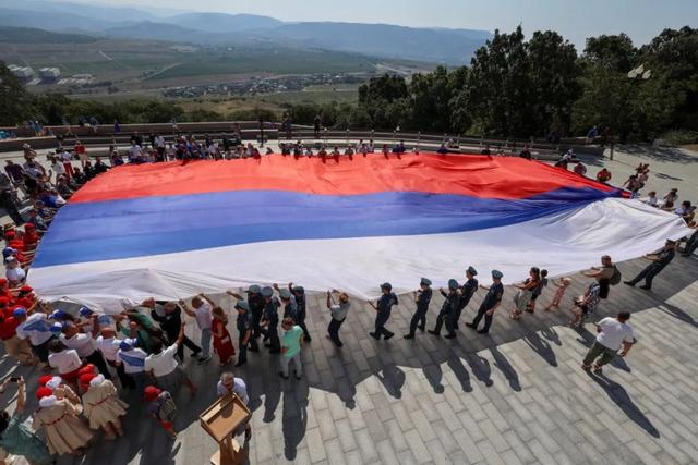 ▲22日，人们在塞瓦斯托波尔展示俄罗斯国旗。（路透社）