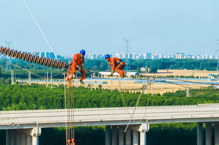聊城供电公司员工在220千伏岳谷线上安装附件。（赵寰 摄）