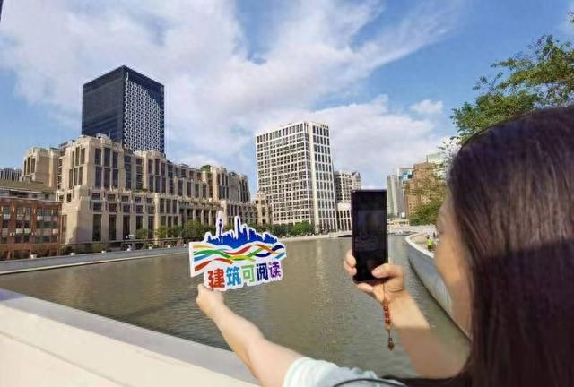 参加“建筑可阅读”主题线路的游客在苏州河畔打卡。资料图片