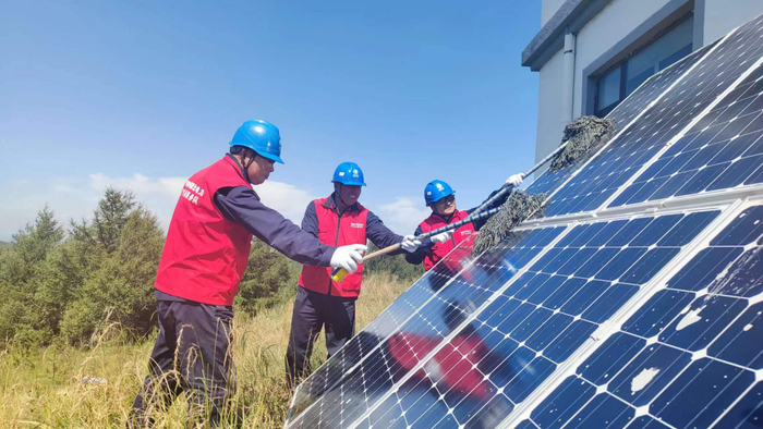 图四：塞罕坝机械林场供电所志愿服务队在清洁月亮山望海楼的光伏板