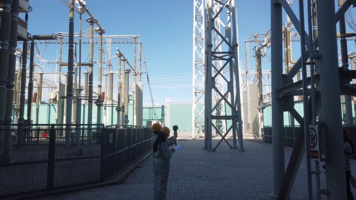 图二：中都换流站的工作人员正在记录数据