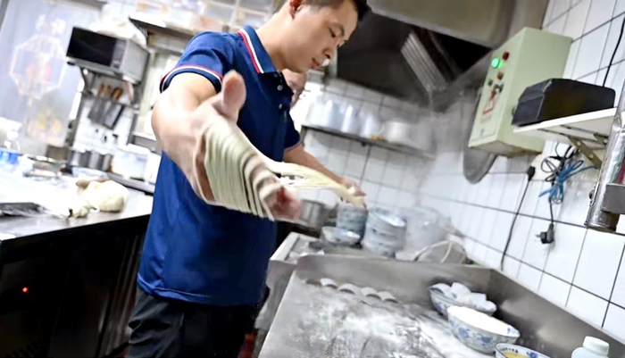 ▲图为余笑源在店内拉面 摄影/朱冲