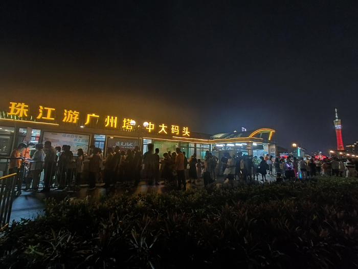 （游客于珠江夜游码头排队等候登船 财联社记者摄）