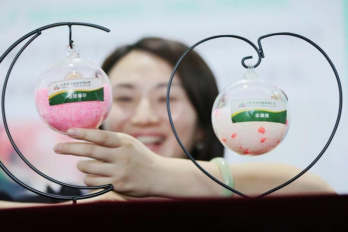  在山东辛化硅胶有限公司，一位采购商在参观猫砂产品。   资料片