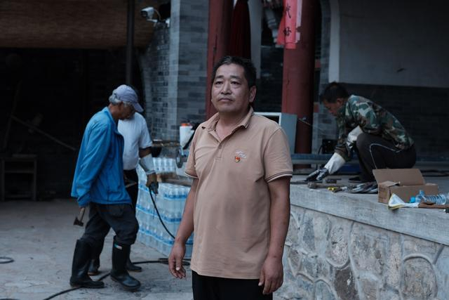 8月15日，记者来到爨底下村，拍下了党支部书记韩跃在村中忙碌的身影。新京报记者 曹晶瑞 摄