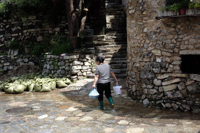 8月15日，穿村而过的石板路上一直流水，村民出门都是穿着雨鞋。新京报记者 曹晶瑞 摄