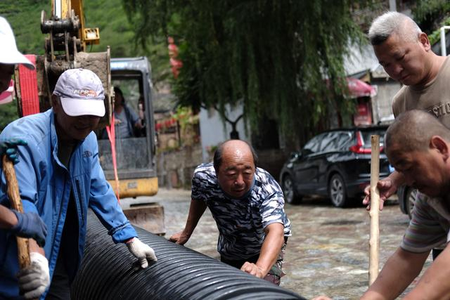 8月25日中午，爨底下村的村民和村干部一起拼接排水管道。新京报记者 曹晶瑞 摄