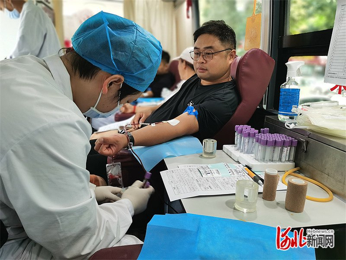 8月7日，馆陶县小桔灯无偿献血志愿服务队队员赵德龙在献血车内献血。杲光兴摄