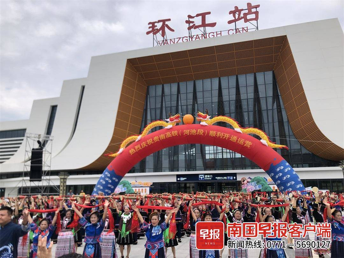 ▲环江毛南族群众在高铁站前载歌载舞。