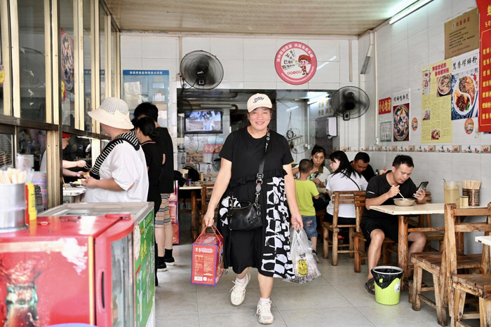 一位食客打包了五碗螺蛳粉和一箱螺蛳粉准备坐火车去黎塘。