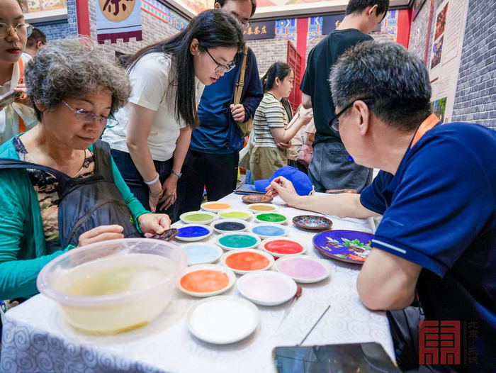 ▲观众在非遗体验区进行“创作”