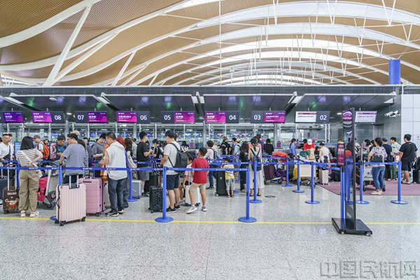 暑运期间旅客在浦东机场T2吉祥航空值机区有序排队办理托运手续