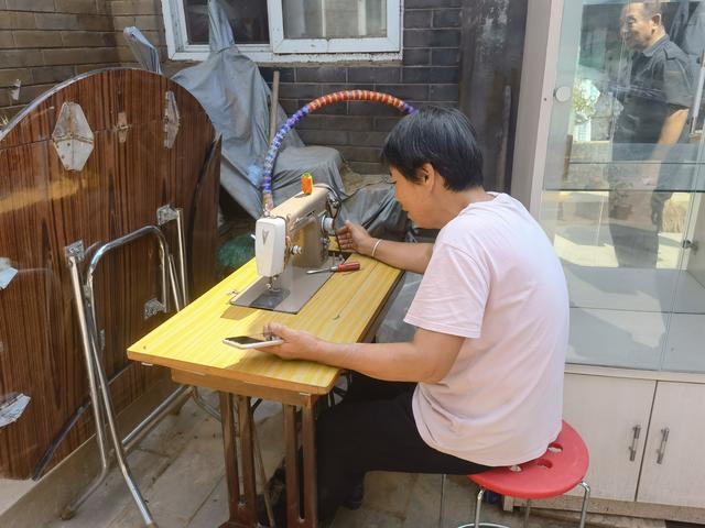 9月1日，李凤花在修缝纫机。新京报记者 周怀宗 摄