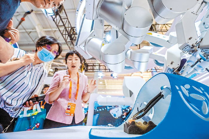 　　展商演示单孔腔镜手术机器人剥蛋壳。本报记者 武亦彬摄