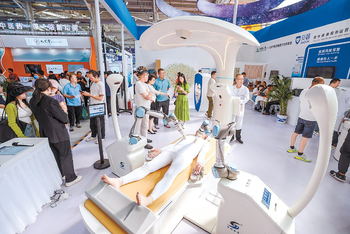 　　展商在展示一台数字中医循经治疗机器人。 本报记者 武亦彬摄