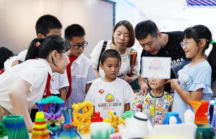 成都七中初中附属小学一年级新生在学校人工智能馆观看3D打印机打印的作品。新华社记者邢拓 摄