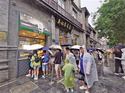 游客冒雨到吴裕泰排队购买冰淇淋。新京报首席记者 郭铁 摄